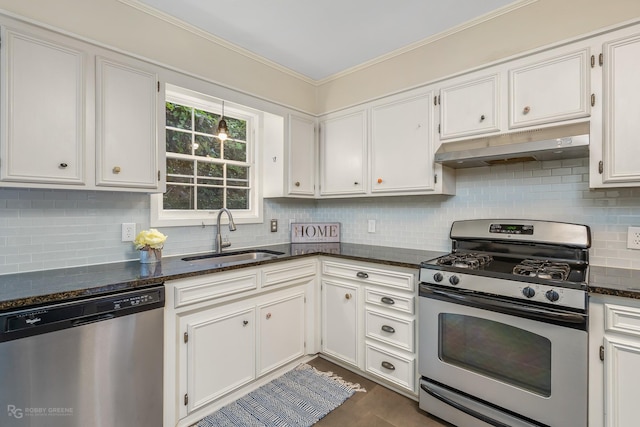 kitchen featuring appliances with stainless steel finishes, tasteful backsplash, sink, dark stone countertops, and white cabinetry