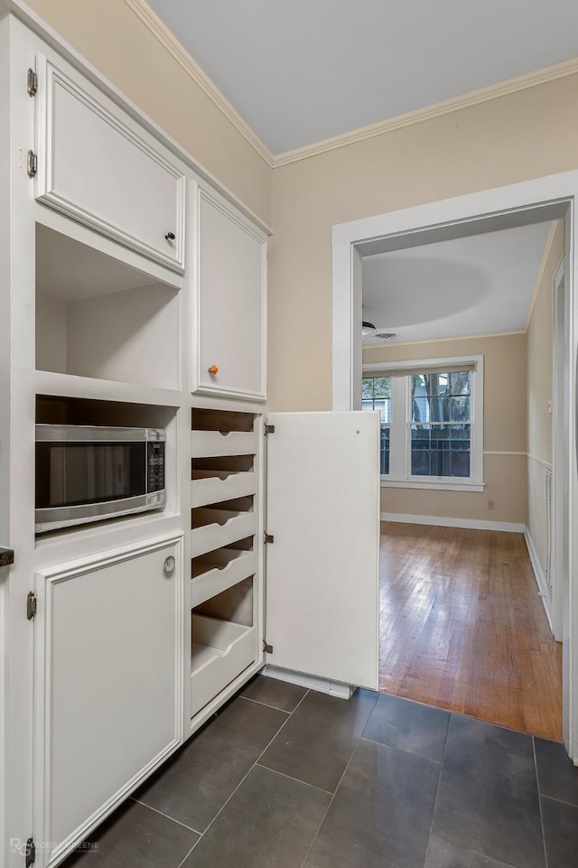 interior space with dark tile patterned flooring and crown molding