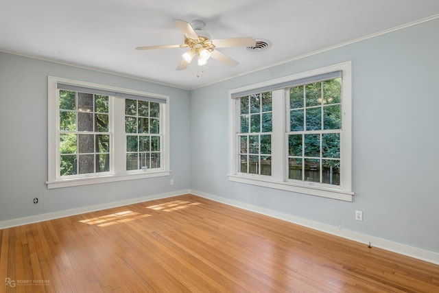 empty room featuring ceiling fan, wood-type flooring, and crown molding