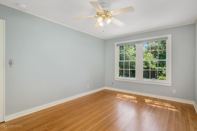 spare room with wood-type flooring, ceiling fan, and ornamental molding