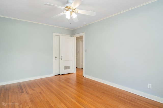 unfurnished room featuring ceiling fan, light wood-type flooring, and crown molding