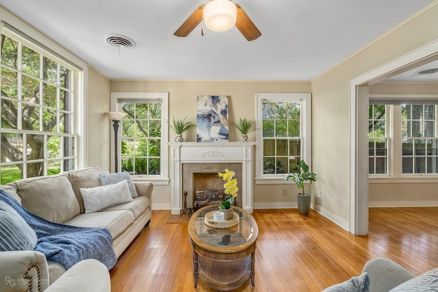 living room featuring ceiling fan, light hardwood / wood-style floors, and ornamental molding