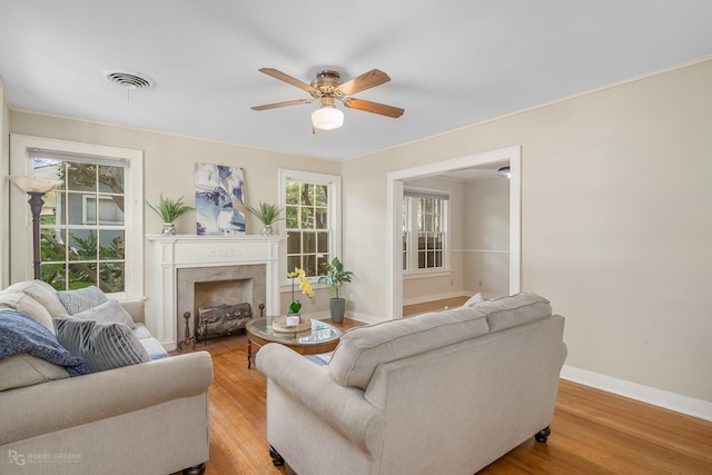 living room with light hardwood / wood-style floors, plenty of natural light, and ceiling fan