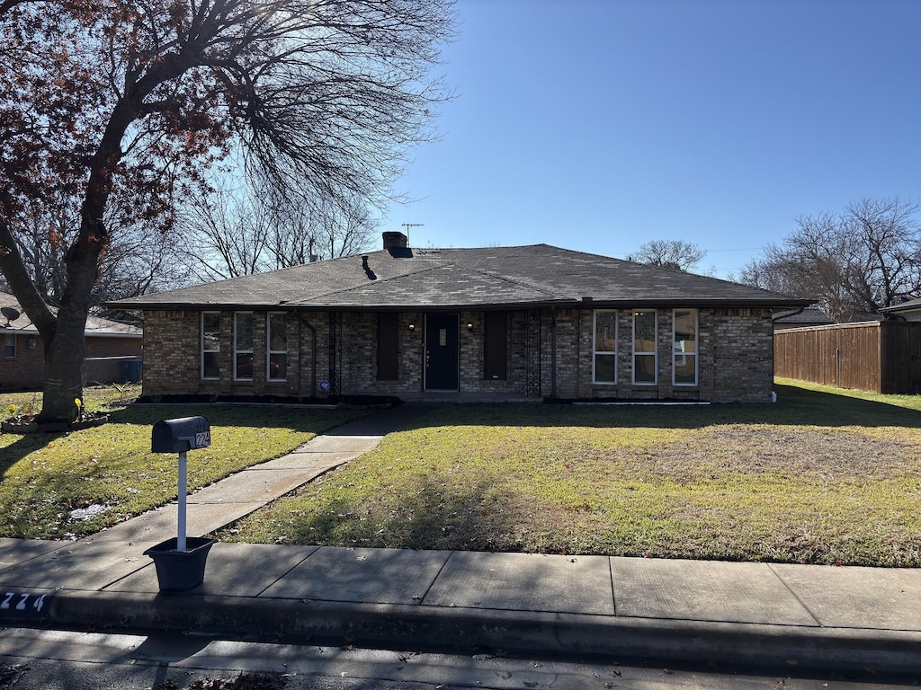 single story home with a front lawn