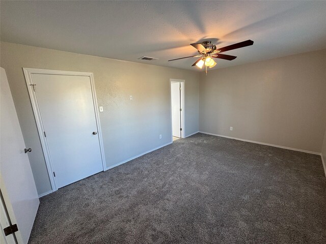 carpeted spare room featuring ceiling fan and a textured ceiling