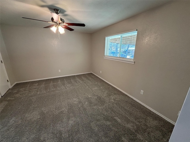 unfurnished room featuring ceiling fan and dark carpet