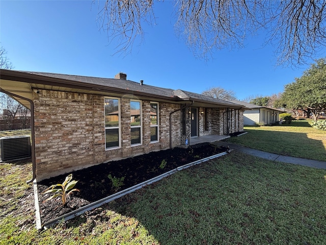 view of front of home with central AC unit and a front lawn