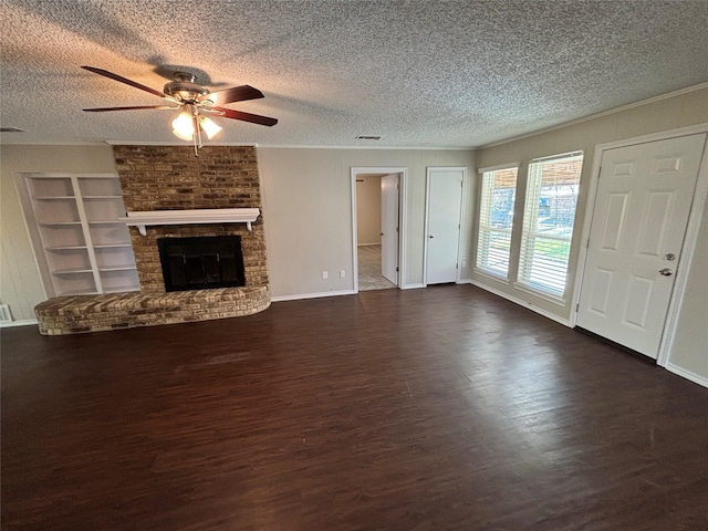 unfurnished living room with crown molding, a textured ceiling, dark hardwood / wood-style flooring, ceiling fan, and a fireplace