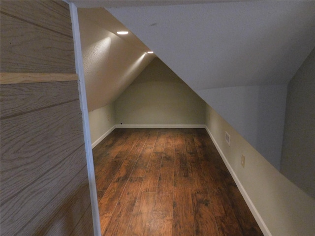 additional living space with dark hardwood / wood-style flooring and lofted ceiling