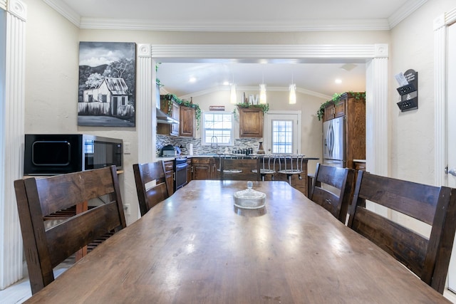 dining room with crown molding and vaulted ceiling