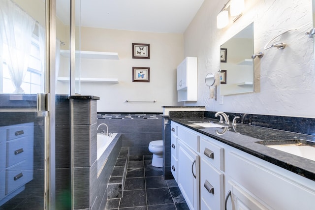 bathroom featuring tile walls, tile patterned flooring, vanity, a relaxing tiled tub, and toilet