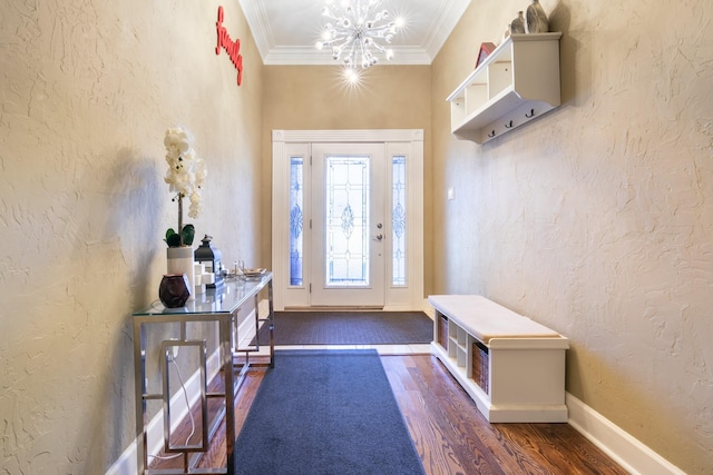 foyer entrance with ornamental molding, dark wood-type flooring, and an inviting chandelier