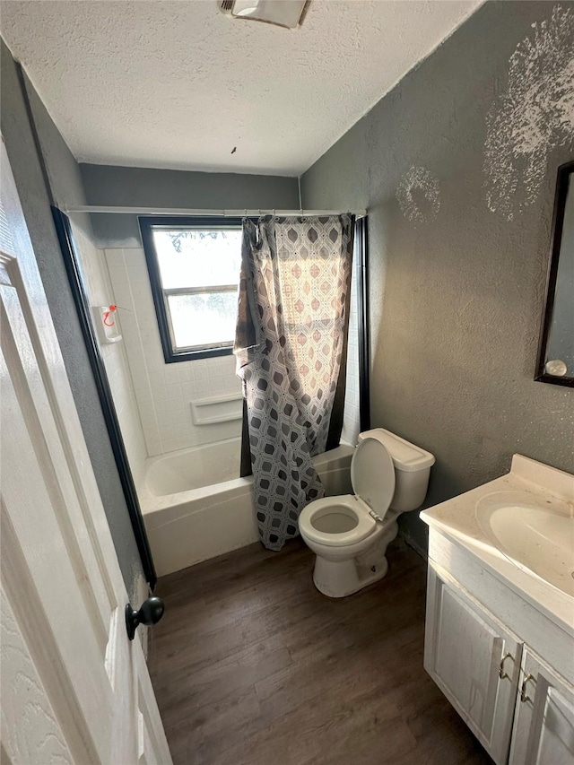 full bathroom featuring hardwood / wood-style floors, shower / bath combination with curtain, a textured ceiling, and vanity