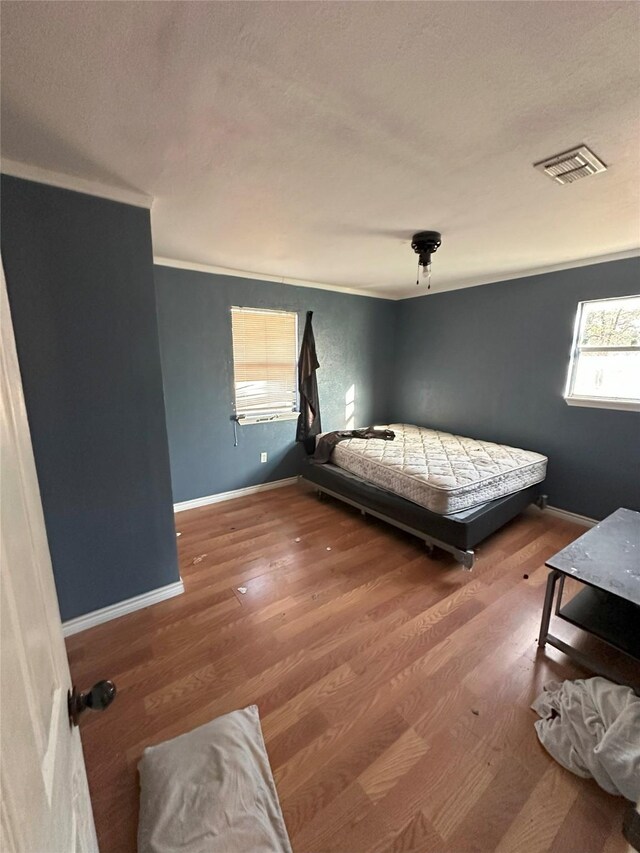 bedroom featuring hardwood / wood-style flooring and crown molding