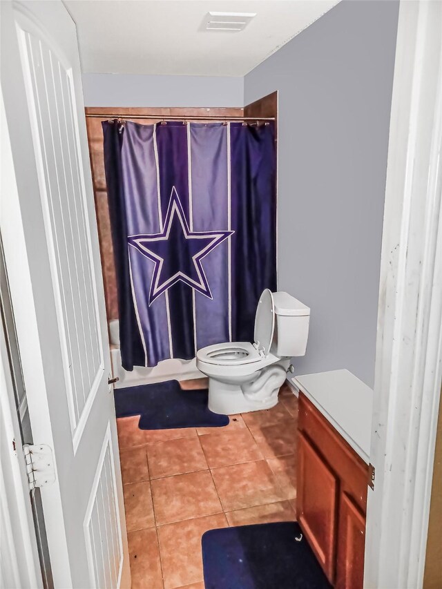 bathroom featuring tile patterned flooring, shower / bath combo, and toilet