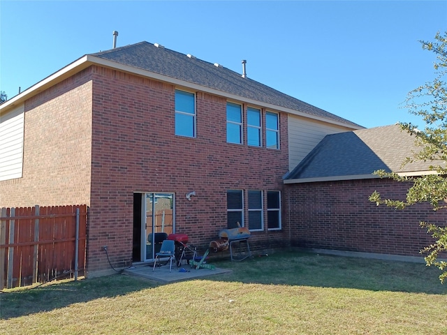 back of house with a lawn and a patio