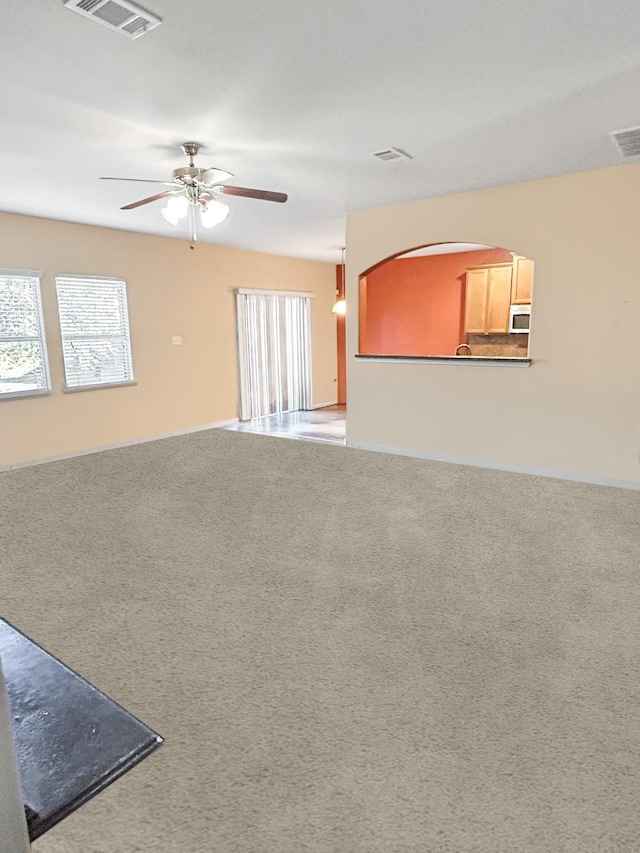 carpeted spare room featuring ceiling fan