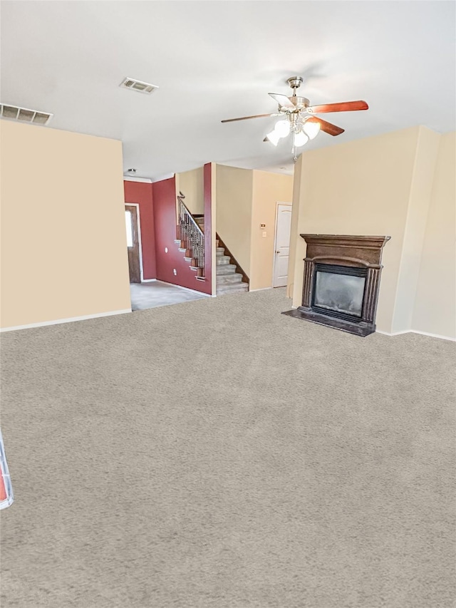 unfurnished living room featuring ceiling fan and carpet