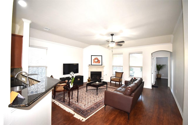 living room with dark hardwood / wood-style floors, ceiling fan, crown molding, and sink