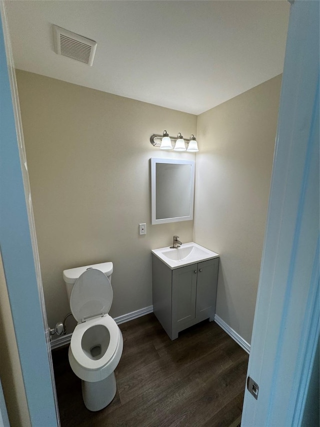 bathroom with vanity, hardwood / wood-style floors, and toilet