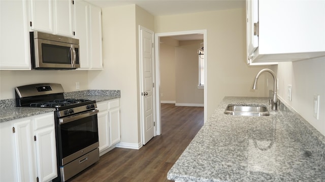 kitchen with white cabinetry, sink, light stone counters, and stainless steel appliances