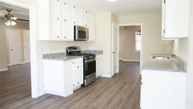 kitchen featuring white cabinetry, stainless steel appliances, light stone countertops, and sink