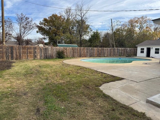 view of yard featuring a fenced in pool, a patio, and an outbuilding