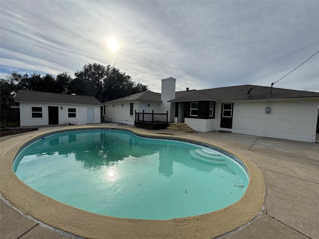 view of swimming pool featuring a patio and an outdoor structure