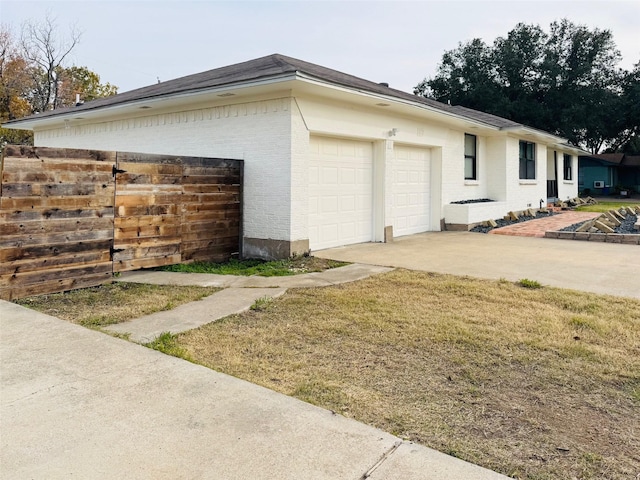 view of property exterior featuring a garage and a yard