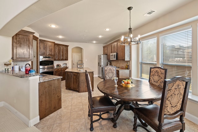 tiled dining area with an inviting chandelier