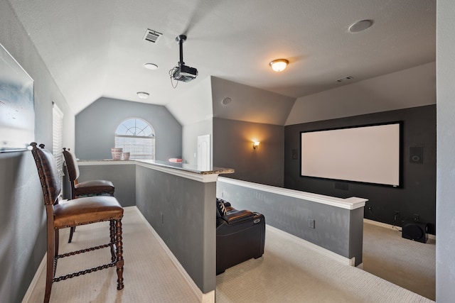 cinema with light carpet and vaulted ceiling