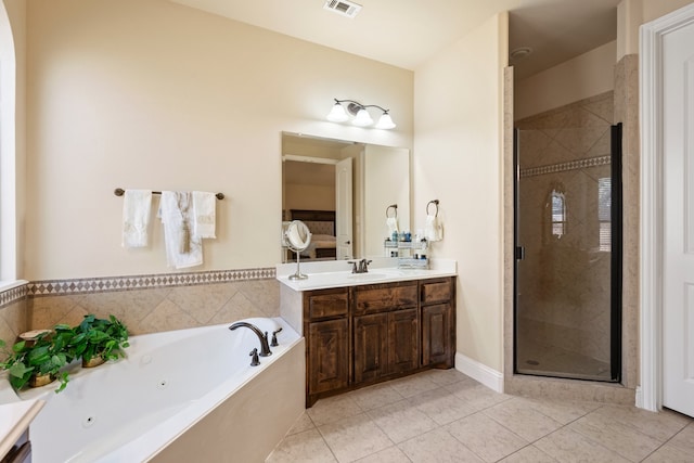 bathroom with tile patterned floors, vanity, and shower with separate bathtub