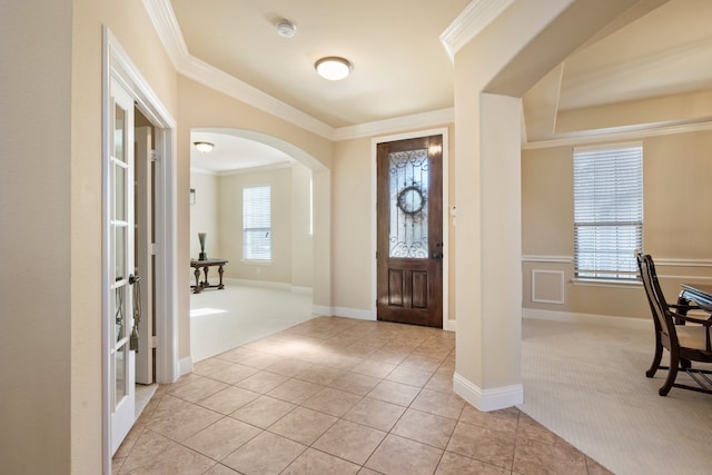 carpeted entryway with crown molding and french doors