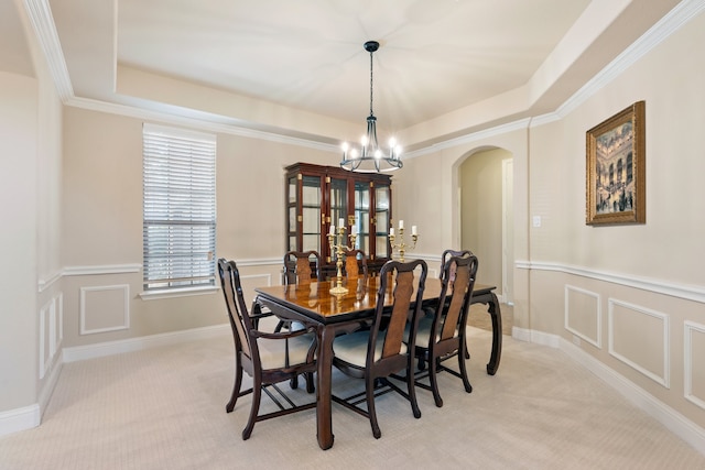 carpeted dining area featuring an inviting chandelier, crown molding, and a raised ceiling