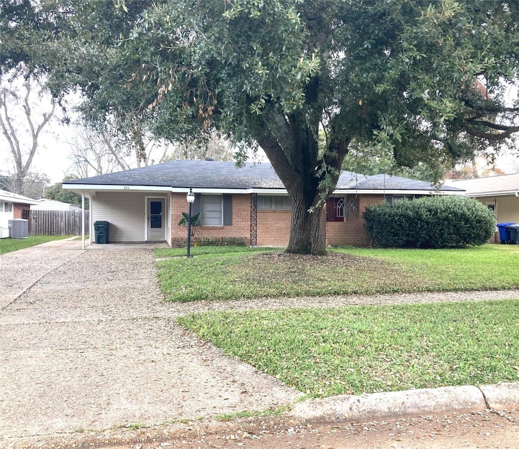 ranch-style home with a carport, a front lawn, and central AC