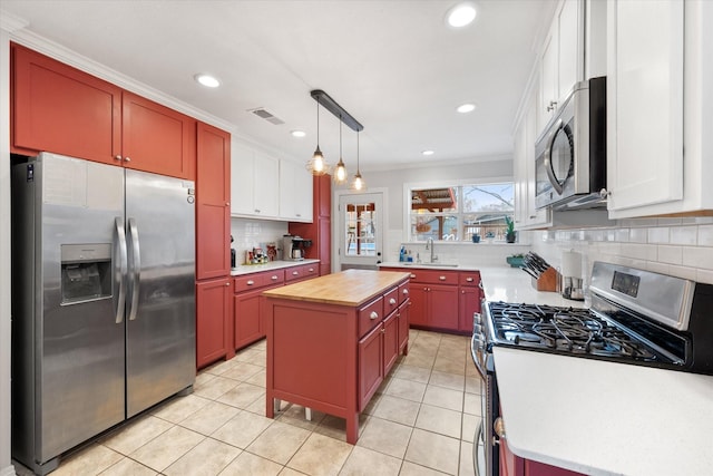 kitchen with stainless steel appliances, white cabinetry, and a center island