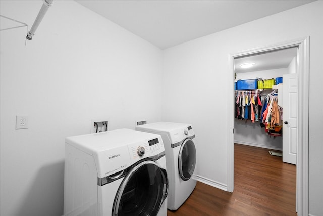 laundry room featuring washer and dryer and dark wood-type flooring