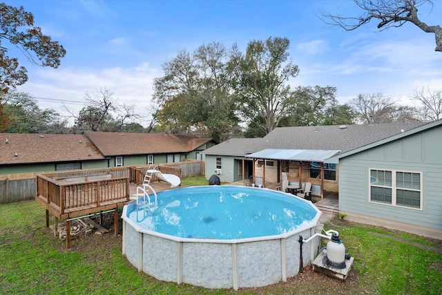 view of pool with a wooden deck, a yard, and a water slide