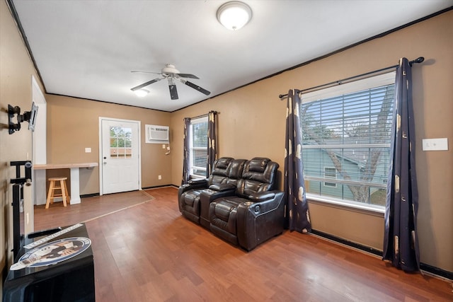 living room featuring crown molding, ceiling fan, hardwood / wood-style floors, and a wall unit AC