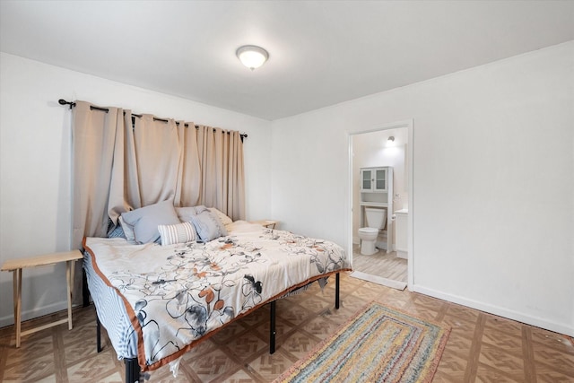 bedroom with connected bathroom and parquet floors