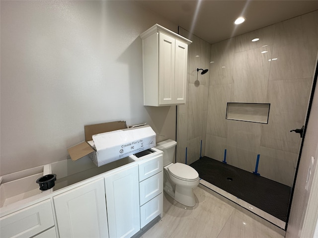 bathroom featuring tiled shower, sink, and toilet