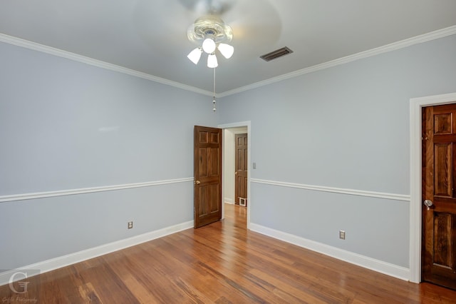 spare room with hardwood / wood-style floors, ceiling fan, and crown molding