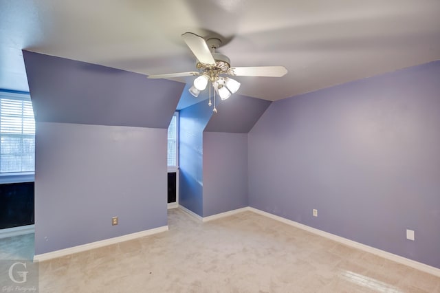 additional living space with ceiling fan, light colored carpet, and lofted ceiling