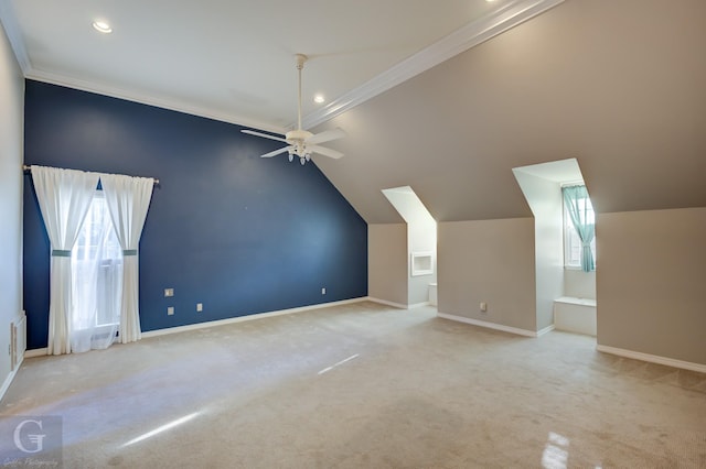 additional living space with ceiling fan, a healthy amount of sunlight, light colored carpet, and lofted ceiling