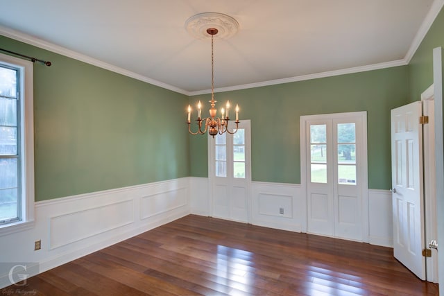 unfurnished dining area featuring dark hardwood / wood-style floors, ornamental molding, a wealth of natural light, and a chandelier