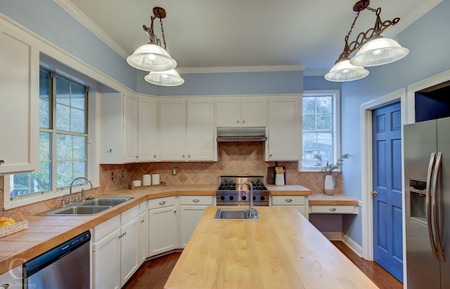 kitchen with pendant lighting, sink, decorative backsplash, appliances with stainless steel finishes, and white cabinetry