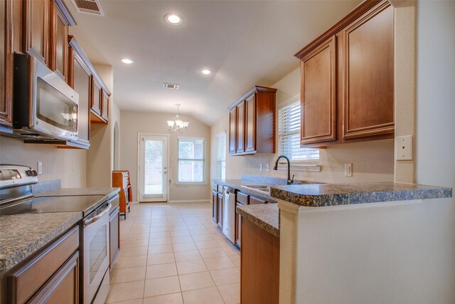 kitchen featuring lofted ceiling, sink, light tile patterned floors, a notable chandelier, and stainless steel appliances