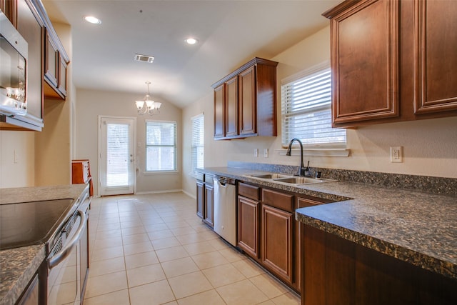 kitchen featuring sink, vaulted ceiling, light tile patterned floors, appliances with stainless steel finishes, and pendant lighting