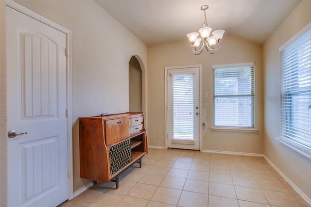 doorway with light tile patterned flooring, lofted ceiling, and a chandelier