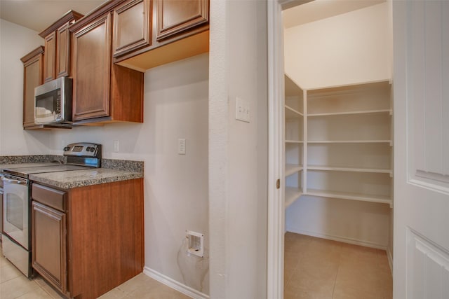 kitchen featuring light tile patterned flooring and stainless steel appliances